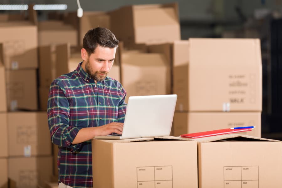 Person paying storage bill surrounded by boxes in storage unit