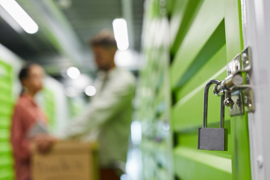 Lock securing storage unit door with tenants in background